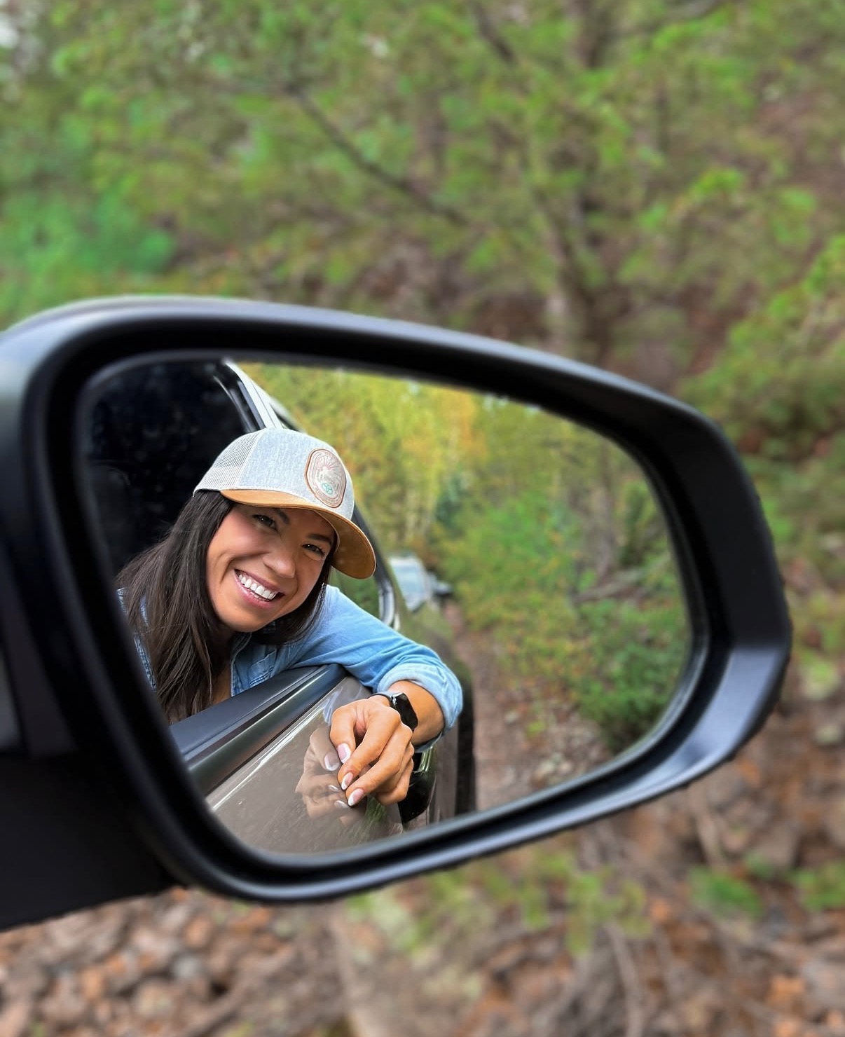 Shannon Roberts smiling in a vehicle side mirror during an Arizona road trip