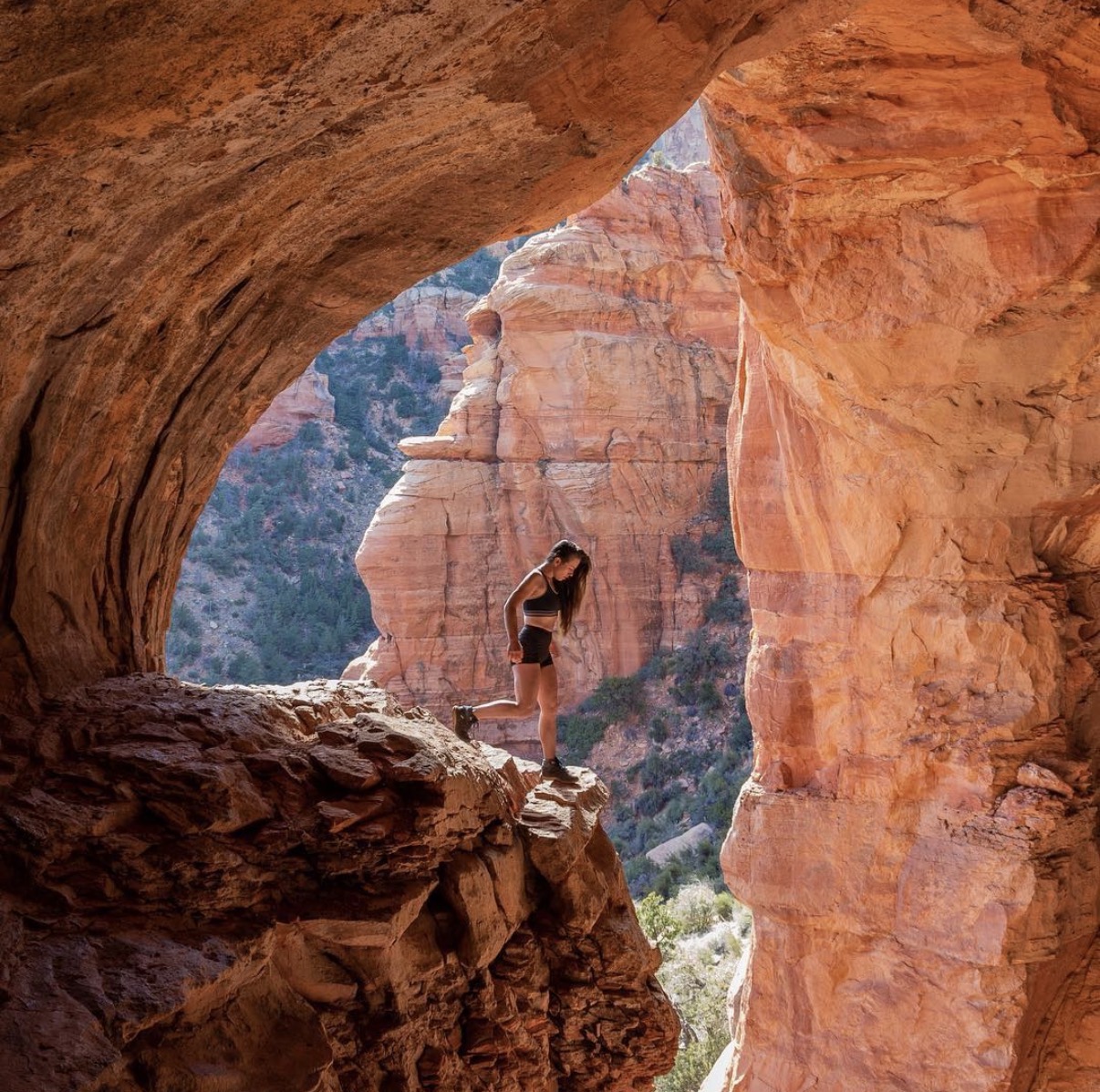Shannon Roberts walking through a red rock cave in Sedona, Arizona