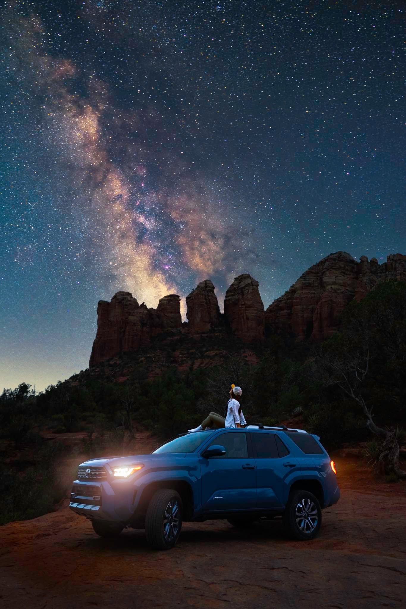 Shannon Roberts seated on a Toyota beneath the Milky Way and Sedona red rocks