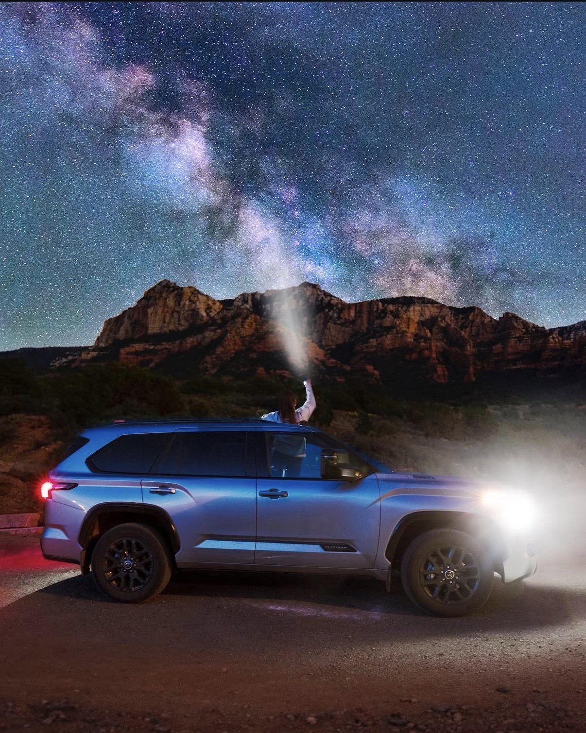 Shannon beneath the Milky Way beside a Toyota in Arizona